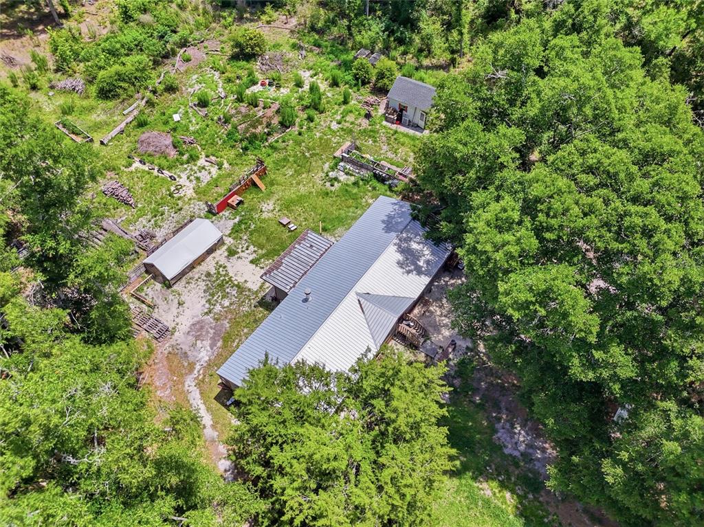 An aerial view shows a house with a metal roof surrounded by trees and outbuildings — 12725 212TH TERRACE, O'BRIEN, FL