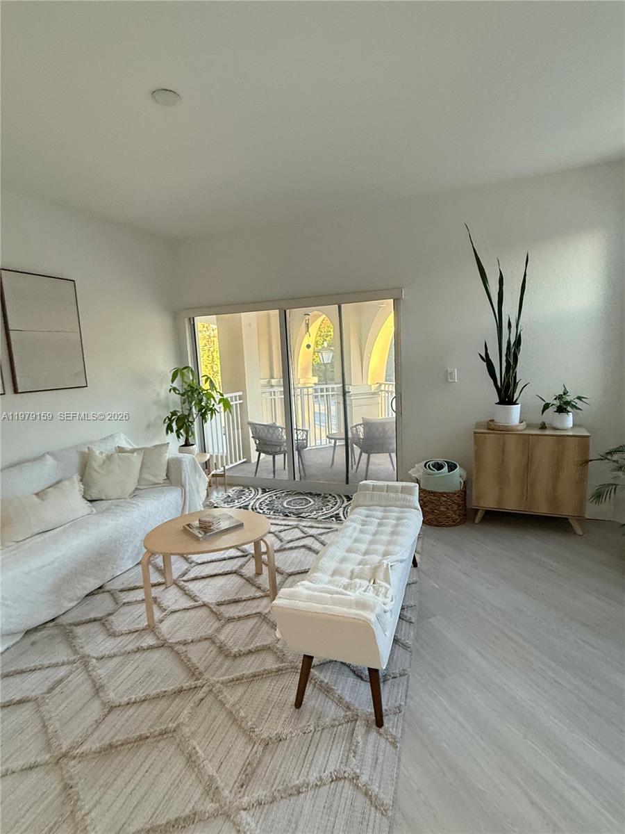 A living room features a white sofa, a bench, a coffee table, and a balcony — 8999 NW 107th Ct # 1, Doral FL 33178, DORAL, FL