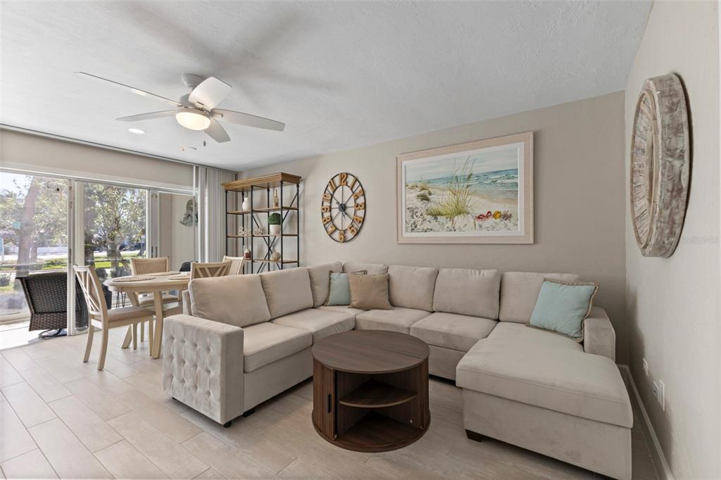 A living room features a beige sectional sofa, a round coffee table, and a dining area — 137 AVENIDA MESSINA UNIT 1, SARASOTA, FL