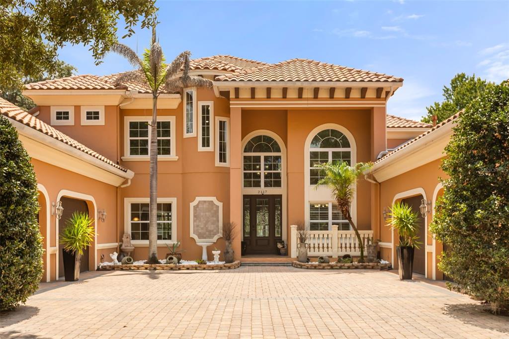 A two-story stucco house with a tile roof and a paved driveway in front — 2117 STURBRIDGE COURT, WINTER SPRINGS, FL