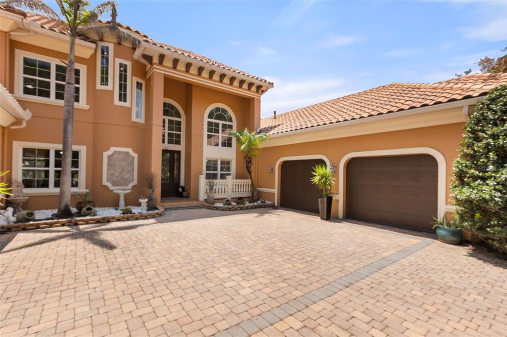 A two-story house with a terracotta tile roof, stucco exterior, and a paved driveway — 2117 STURBRIDGE COURT, WINTER SPRINGS, FL