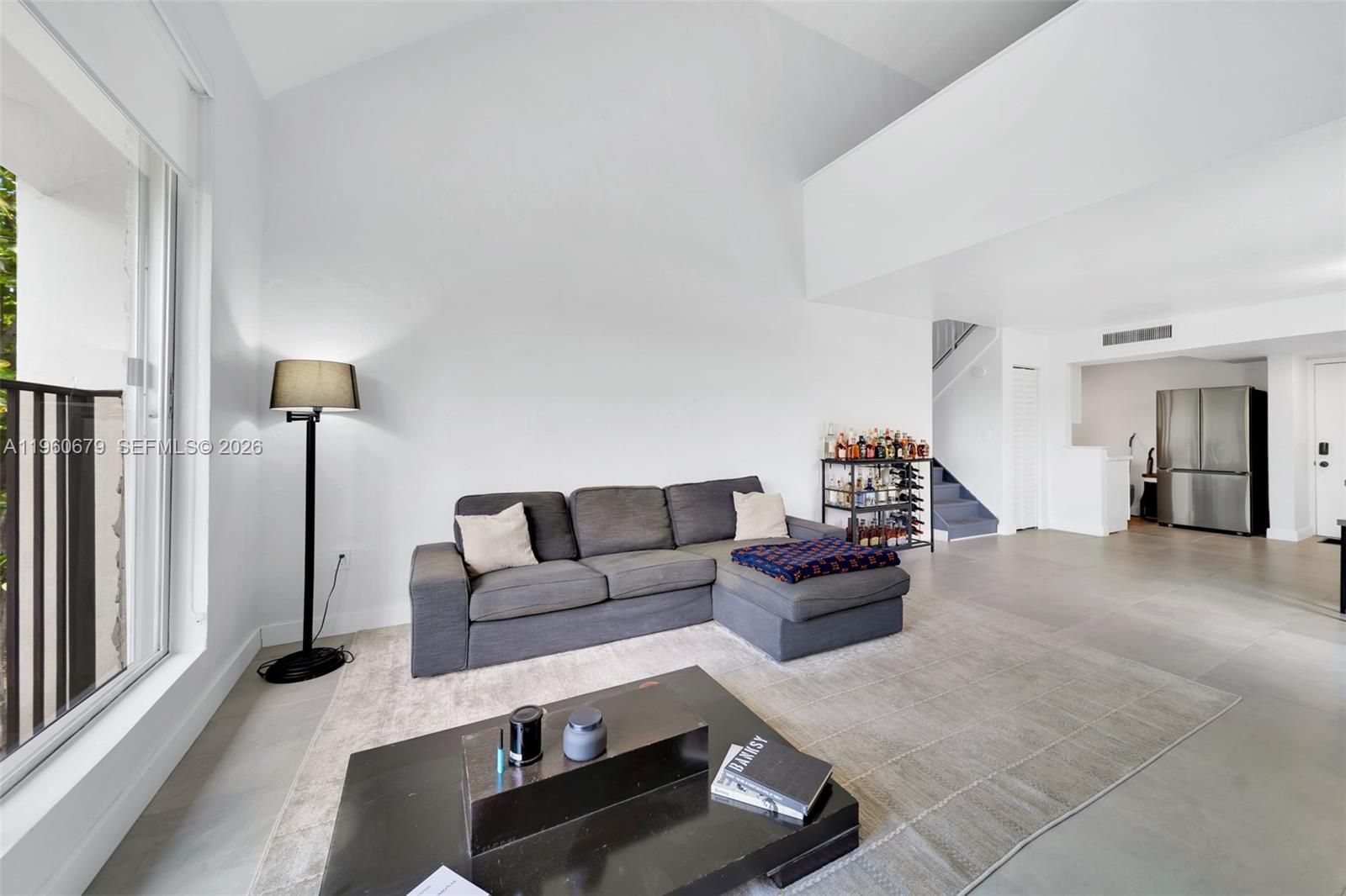 A living room features a grey sectional sofa, a coffee table, and a bar cart — 6900 N Kendall Dr # A303, Pinecrest FL 33156, PINECREST, FL