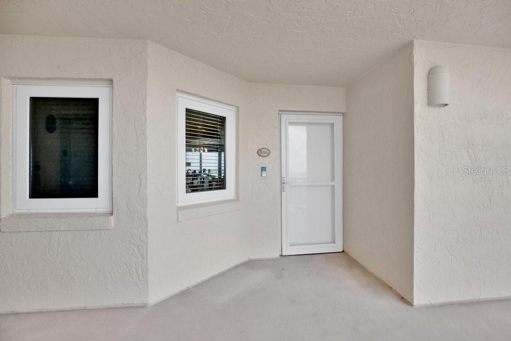 A beige exterior entryway features two windows and a white storm door — 257 MINORCA BEACH WAY UNIT 1005, NEW SMYRNA BEACH, FL