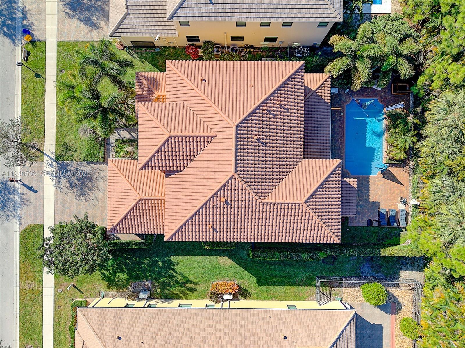 An aerial view shows a house with a tiled roof, a swimming pool, and landscaping — 12097 Boca Reserve Ln, Boca Raton FL 33428, BOCA RATON, FL