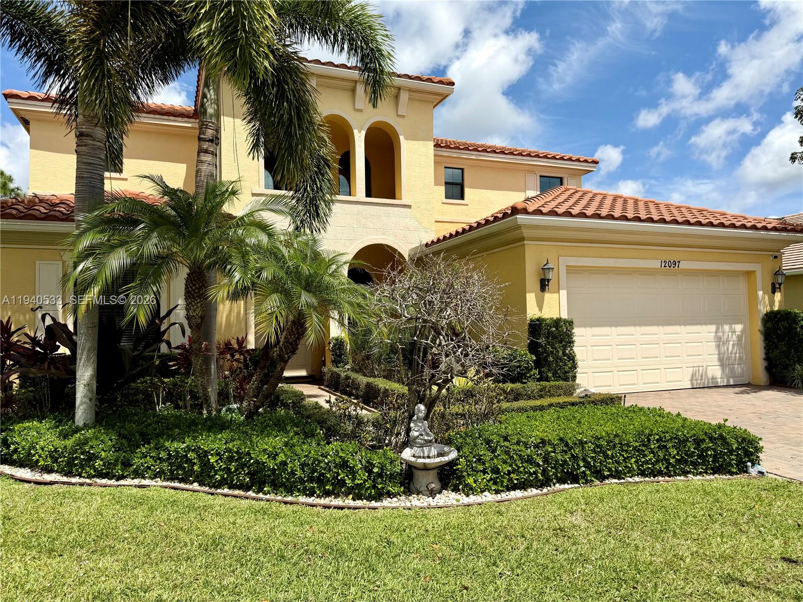 A two-story yellow stucco house features a tile roof, palm trees, and a garage — 12097 Boca Reserve Ln, Boca Raton FL 33428, BOCA RATON, FL