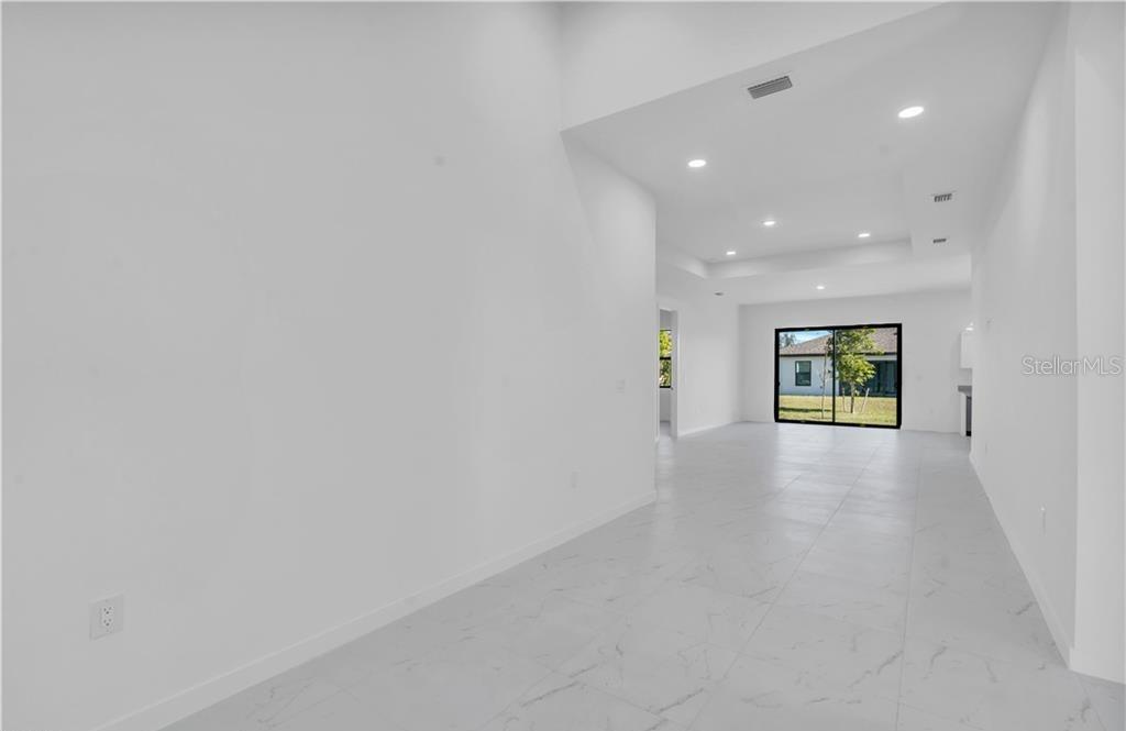 A bright, open-concept living area features white walls, recessed lighting, and light-colored tile flooring — 3617 NW 38TH TERRACE, CAPE CORAL, FL