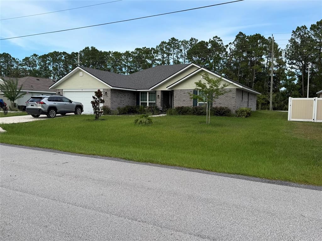 A single-story brick and siding house with a two-car garage and a front lawn — 93 ROYAL OAK DRIVE, PALM COAST, FL