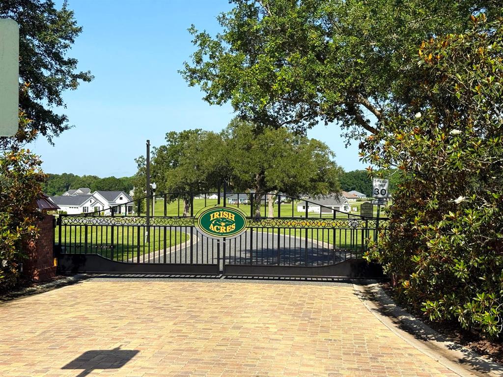 A black metal gate with an Irish Acres sign marks the entrance to a neighborhood — XX NW 17TH CIRCLE, OCALA, FL