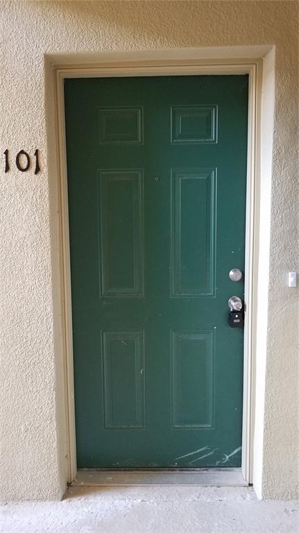 A green six-panel front door with a lockbox is labeled with the number 101 — 6012 PORTSDALE PLACE UNIT 101, RIVERVIEW, FL