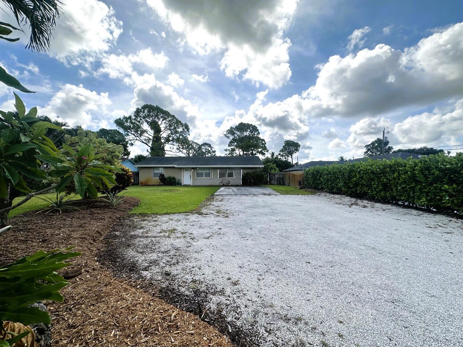 A single-story house with a white front door and a large gravel driveway — 5586 3rd Road, Lake Worth FL 33467, LAKE WORTH, FL