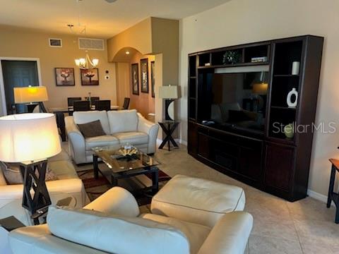 A living room features white leather furniture, a large dark wood entertainment center, and dining area — 8406 GRAND ESTUARY TRAIL UNIT 104, BRADENTON, FL