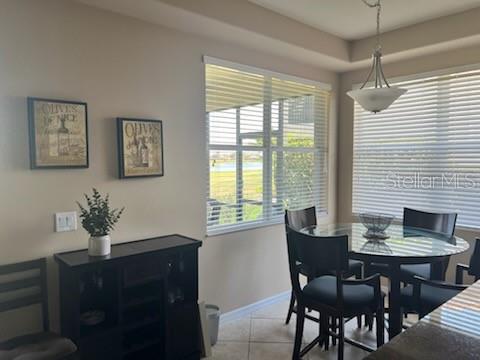 A dining area features a glass-topped table, four chairs, a dark cabinet, and window blinds — 8406 GRAND ESTUARY TRAIL UNIT 104, BRADENTON, FL