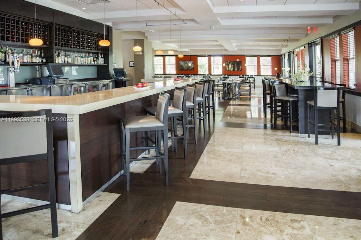 A restaurant interior features a long bar with stools, marble flooring, and pendant lighting — 5300 NW 87th Ave # 1407, Doral FL 33178, DORAL, FL