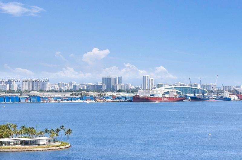 A view of a harbor with cargo ships, shipping containers, and a distant city skyline — 1331 Brickell Bay Dr # 1602, Miami FL 33131, MIAMI, FL