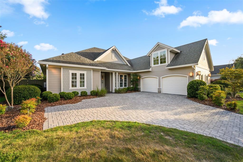 A tan house with a paved driveway, two-car garage, and landscaped front yard — 4074 NW 63RD STREET, GAINESVILLE, FL