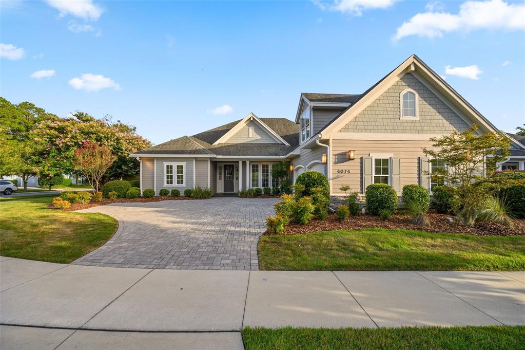 A single-story house with light-colored siding, a paved driveway, and a landscaped front yard — 4074 NW 63RD STREET, GAINESVILLE, FL