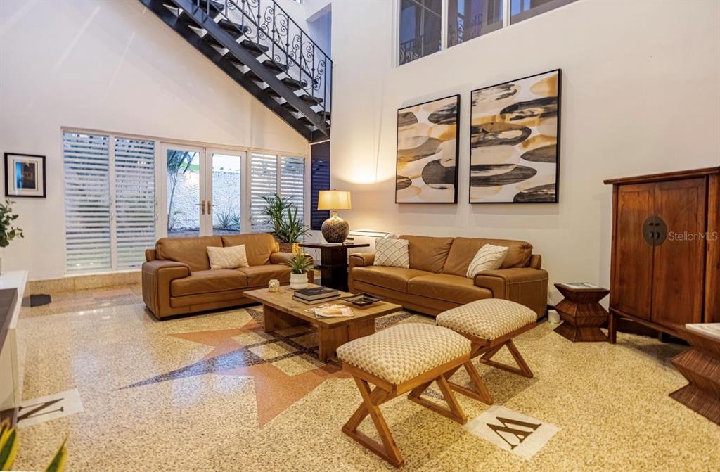 A living room features two leather sofas, a wooden coffee table, and a metal staircase — 1375 MARGINAL VILLAMAR, CAROLINA, PR
