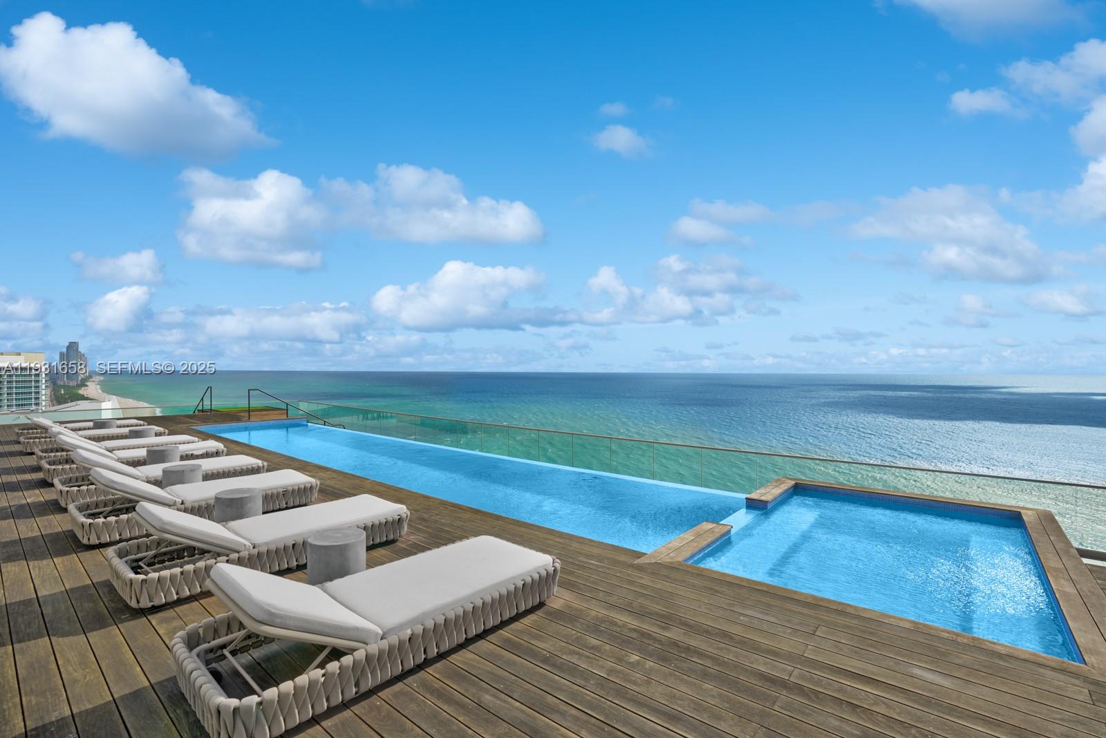 An infinity pool and hot tub overlook the ocean from a wooden deck with loungers — 10203 Collins Ave # 2801, Bal Harbour FL 33154, BAL HARBOUR, FL