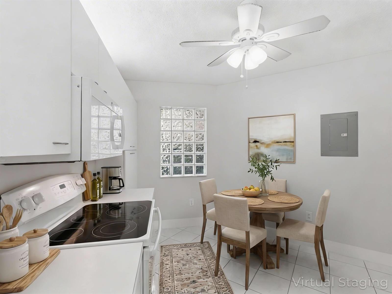 A kitchen with white cabinets, a glass-top stove, and a small dining table with chairs — 5265 Brisata Circle # P, Boynton Beach FL 33437, BOYNTON BEACH, FL