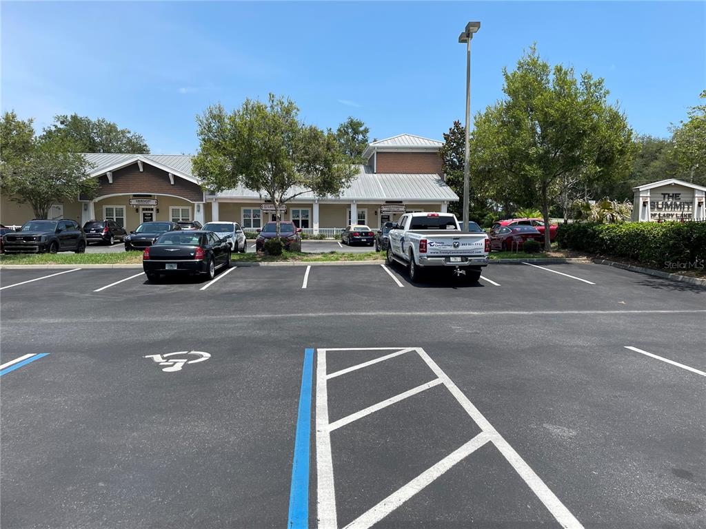 A parking lot sits in front of a commercial building with several parked vehicles — 757 HWY  466 UNIT 100, LADY LAKE, FL