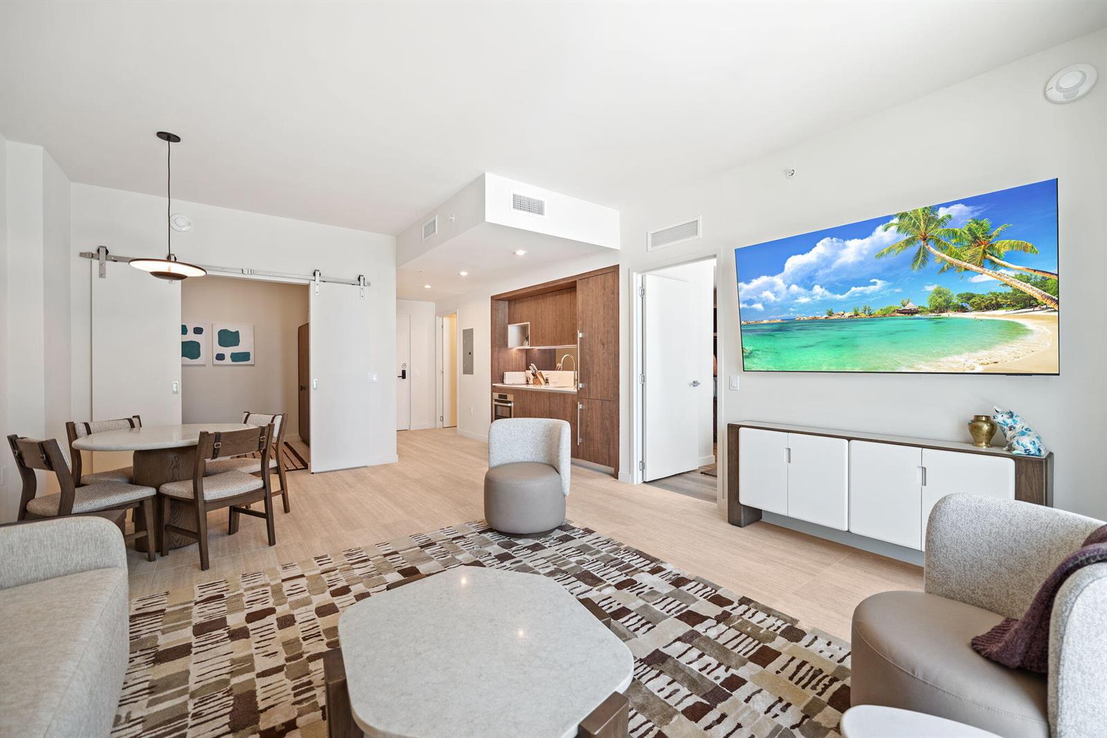 A living room and dining area with light wood floors, modern furniture, and a kitchen — 1611 SW 2nd Avenue # 702, Miami FL 33129, MIAMI, FL