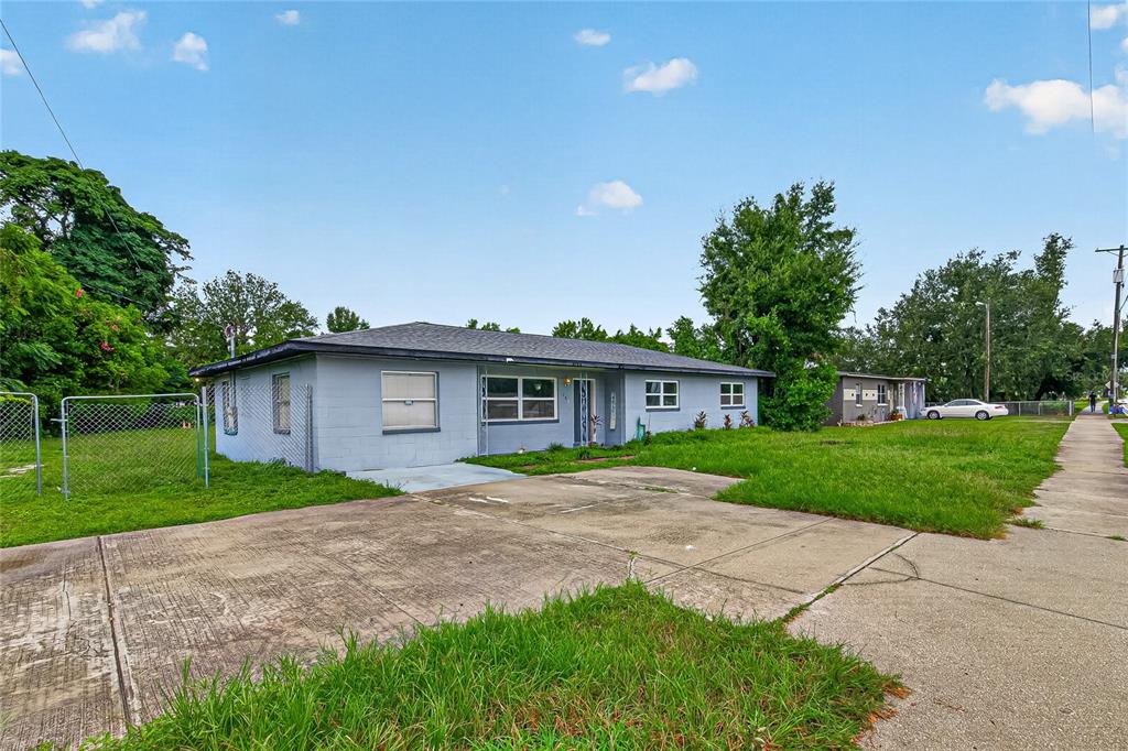 A single-story light blue house with a concrete driveway and a chain-link fence — 708 N PARSONS AVENUE, BRANDON, FL