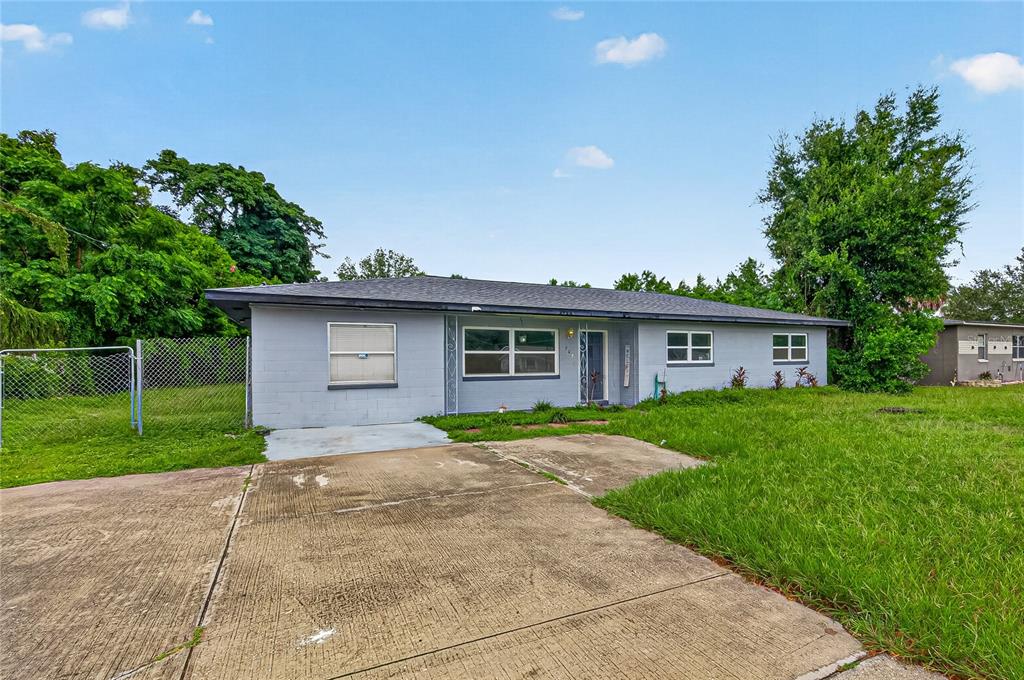 A single-story gray house with a concrete driveway and a chain-link fence — 708 N PARSONS AVENUE, BRANDON, FL
