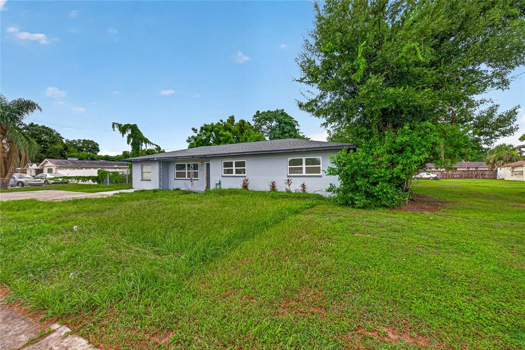 A single-story gray house with a hip roof sits on a large, grassy lot — 708 N PARSONS AVENUE, BRANDON, FL