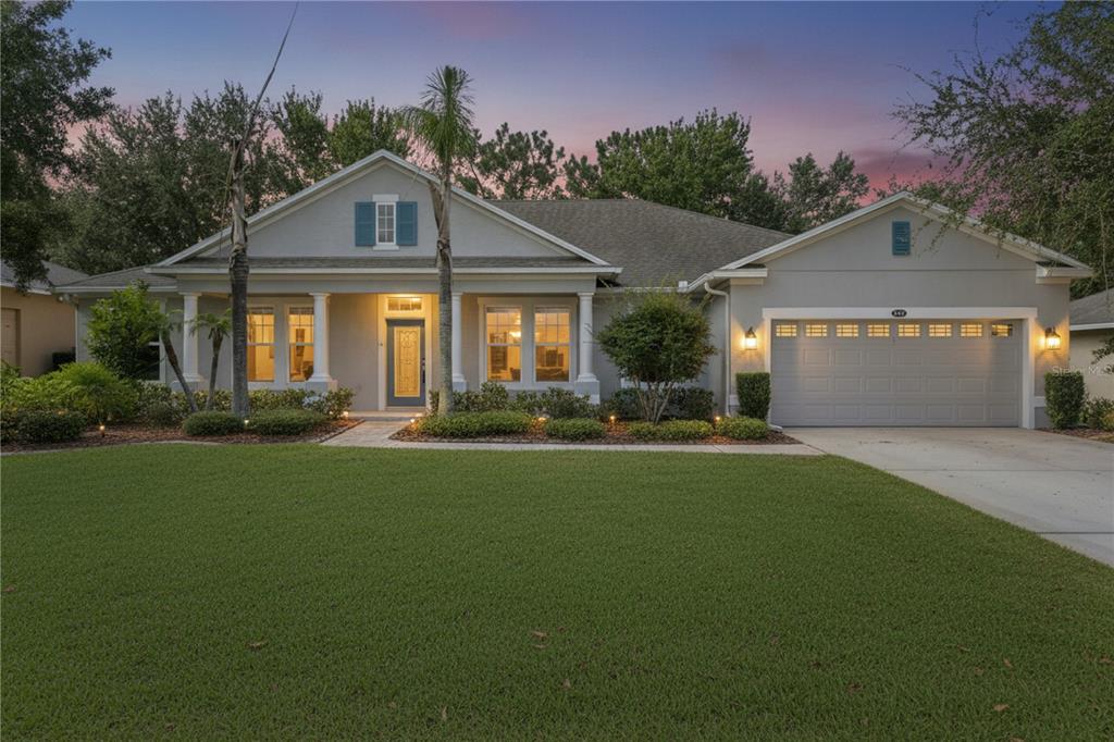 A single-story house with a gray exterior, a two-car garage, and a manicured front lawn — 1041 HARMONY LANE, CLERMONT, FL