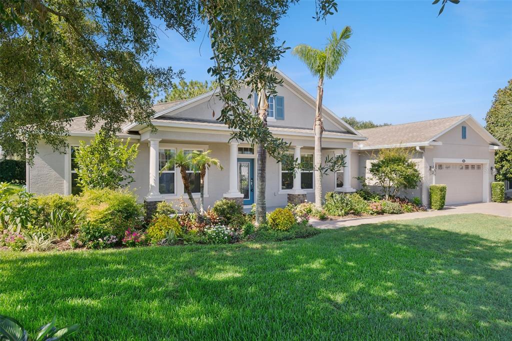 A single-story house with a light-colored exterior, a front porch, and an attached garage — 1041 HARMONY LANE, CLERMONT, FL