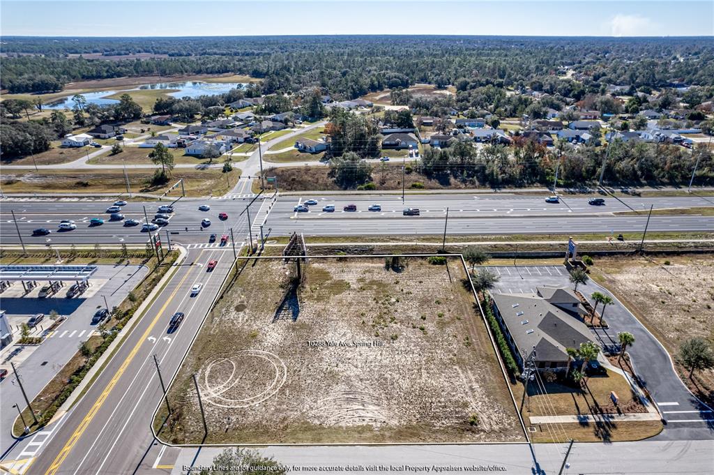 An aerial view shows a vacant rectangular lot situated next to a commercial building — 10288 Lot 8 YALE AVENUE, WEEKI WACHEE, FL