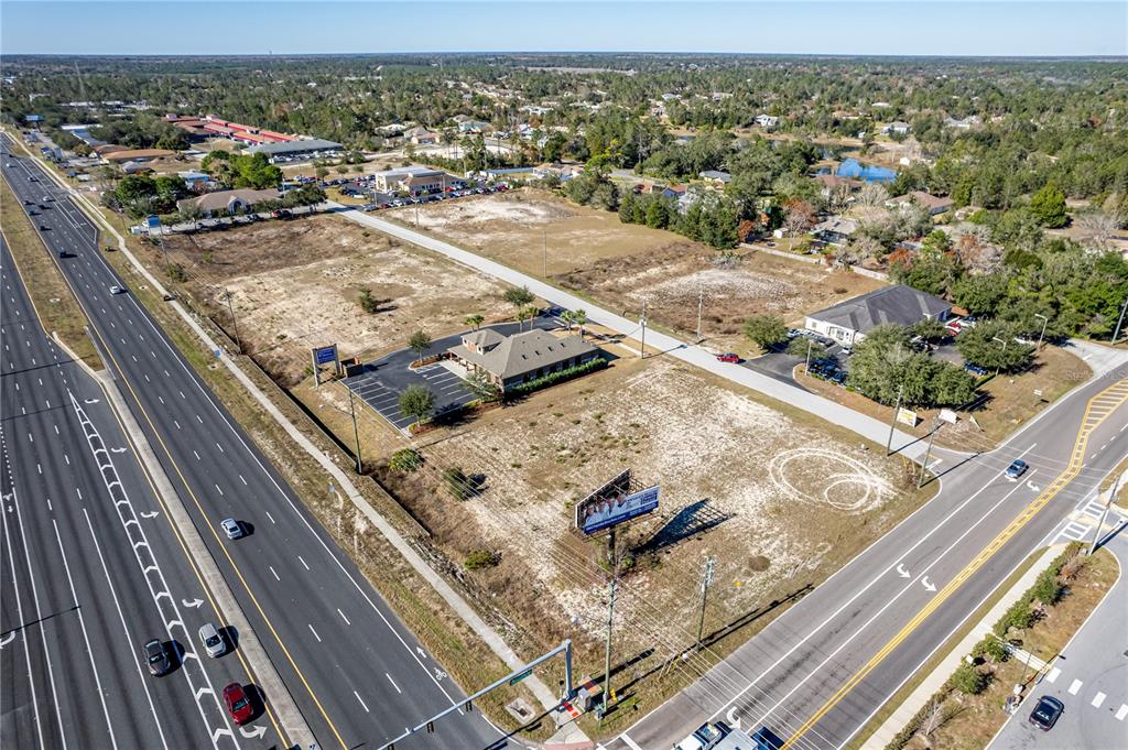 An aerial view shows a commercial building situated on a large, mostly vacant lot — 10288 Lot 8 YALE AVENUE, WEEKI WACHEE, FL
