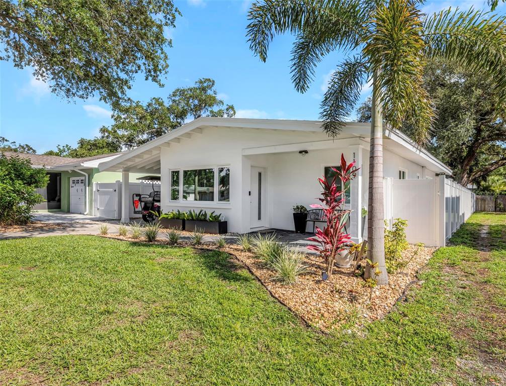 A white single-story house features a covered carport, a front porch, and landscaped yard — 1109 MARINE STREET, CLEARWATER, FL