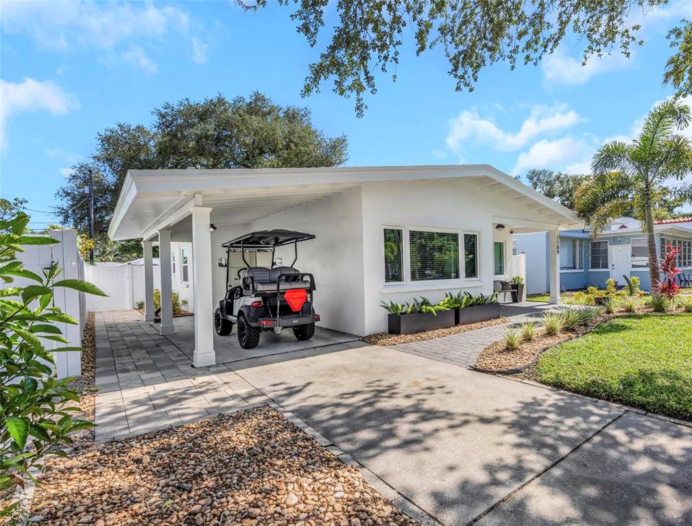 A white single-story house features a paved carport with a golf cart and landscaped yard — 1109 MARINE STREET, CLEARWATER, FL