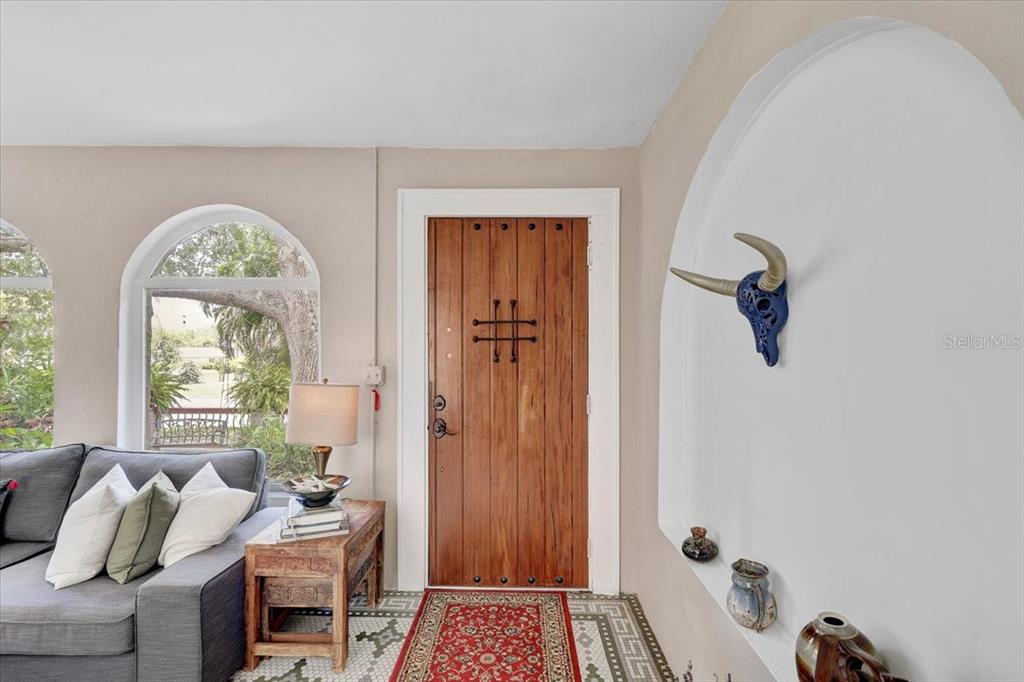 A living area features a wooden door, a gray sofa, and a blue bull skull — 325 49TH STREET N, ST PETERSBURG, FL