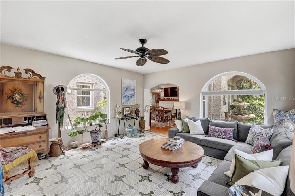 A living room with a gray sectional, round wooden coffee table, and large arched windows — 325 49TH STREET N, ST PETERSBURG, FL