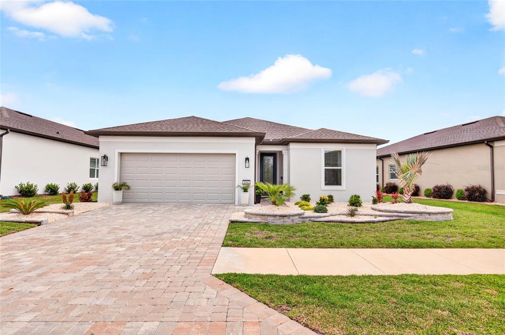 A single-story house with a paved driveway, a two-car garage, and landscaped front yard — 8866 SW 57TH PLACE ROAD, OCALA, FL