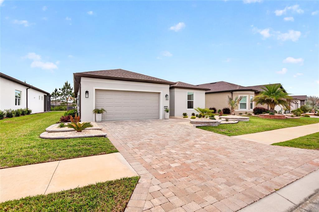 A single-story house with a paved driveway, a two-car garage, and a landscaped front yard — 8866 SW 57TH PLACE ROAD, OCALA, FL