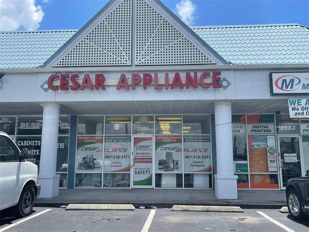 The exterior of a commercial storefront for Cesar Appliance with a blue metal roof — 2585 ORANGE BLOSSOM, KISSIMMEE, FL