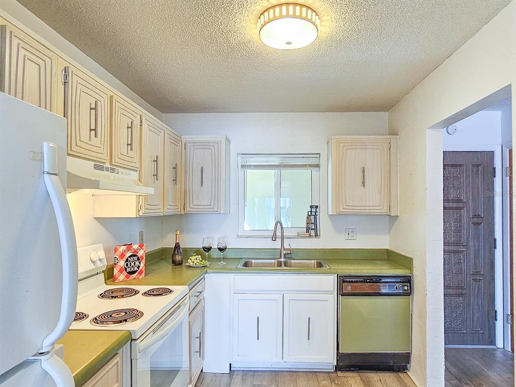 A kitchen features light-colored cabinets, green countertops, a white stove, and a dishwasher — 3606 S PENINSULA DRIVE UNIT 809, PORT ORANGE, FL