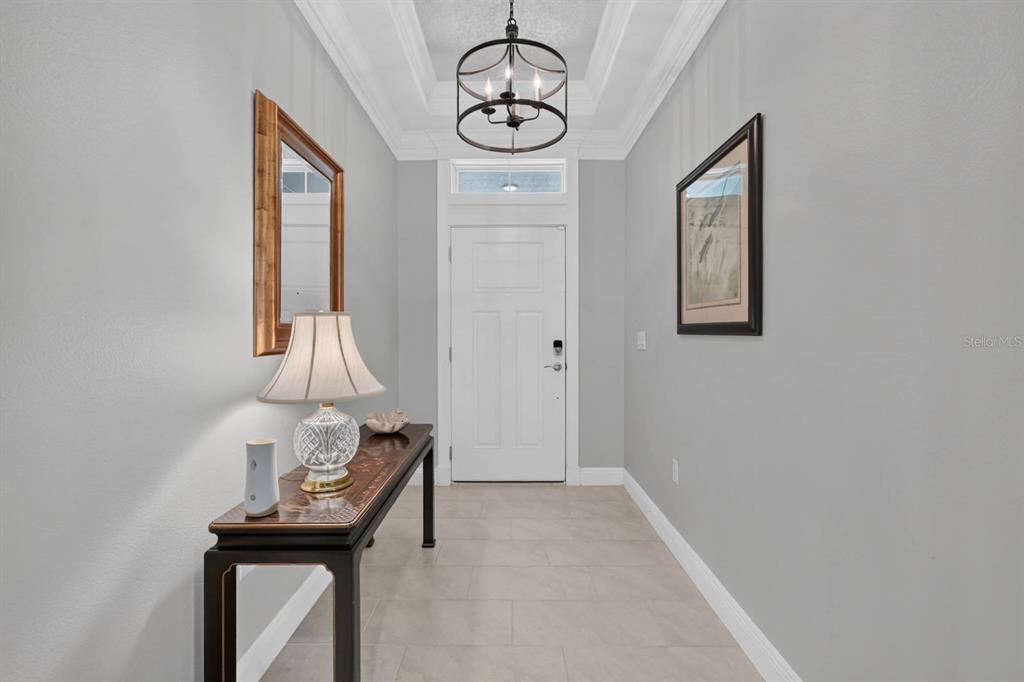 A foyer features a console table, a lamp, a mirror, and a hanging light fixture — 2881 MONAGHAN DRIVE, ORMOND BEACH, FL