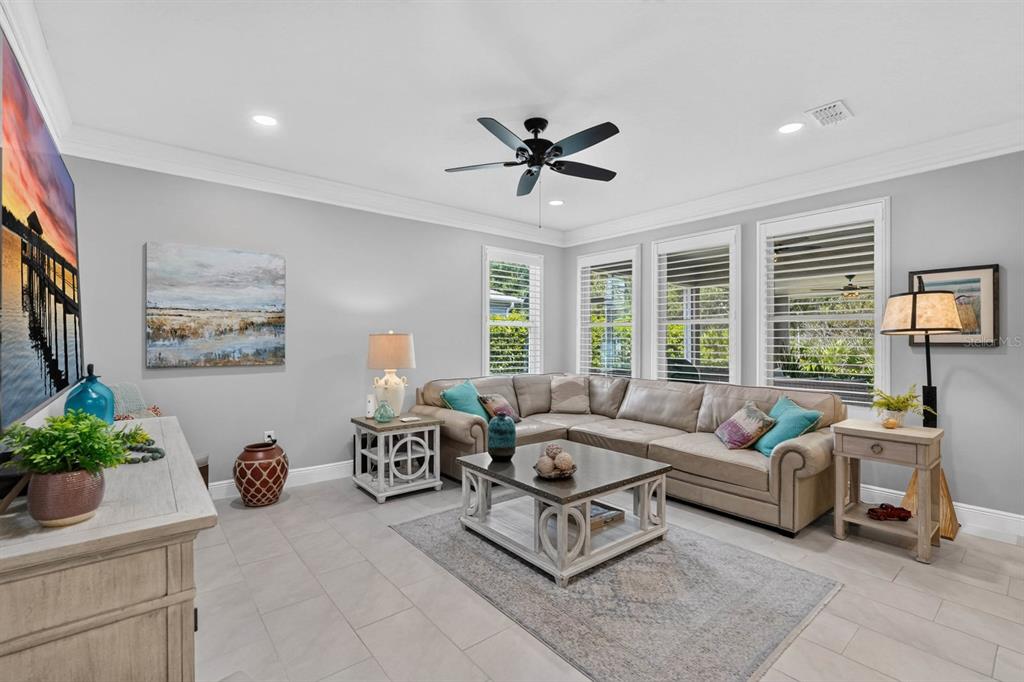 A living room features a beige sectional sofa, a coffee table, and a ceiling fan — 2881 MONAGHAN DRIVE, ORMOND BEACH, FL