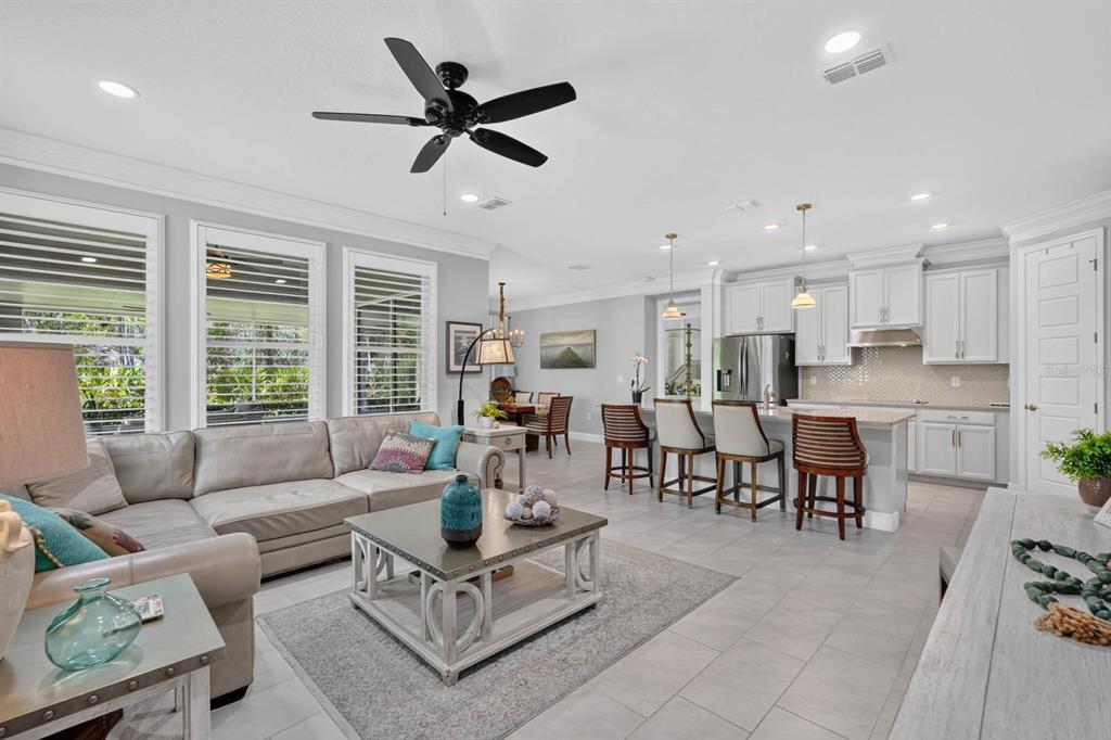An open-concept living room and kitchen featuring light gray walls, tile floors, and white cabinetry — 2881 MONAGHAN DRIVE, ORMOND BEACH, FL