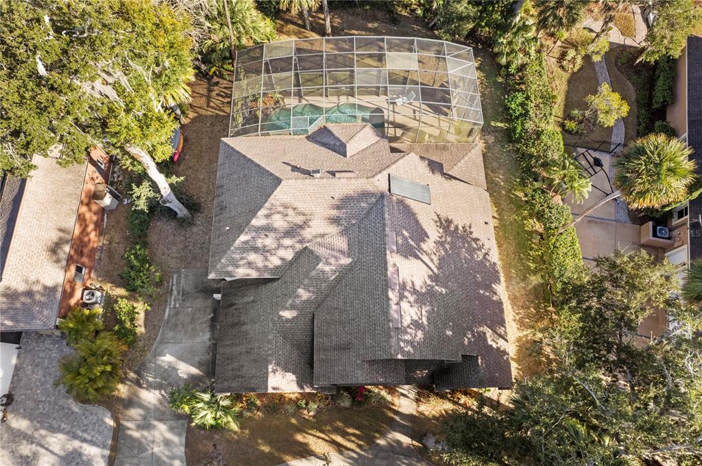 An aerial view shows a house with a shingled roof and a screened-in pool enclosure — 6311 PALMAS BAY CIRCLE, PORT ORANGE, FL