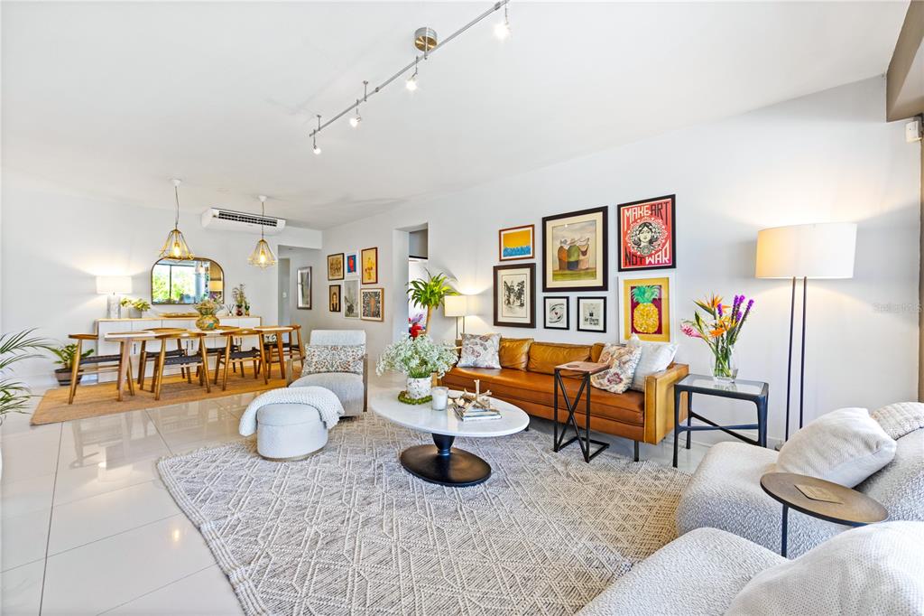 A bright living and dining area features a leather sofa, patterned rug, and track lighting — 1504 AVE. ASHFORD, COND. SEA VIEW UNIT 2C, SAN JUAN, PR
