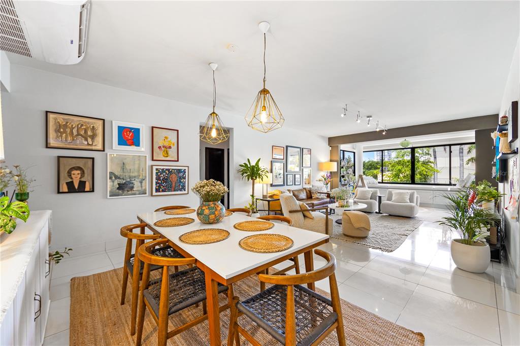An open-concept dining and living area features white tile floors, modern lighting, and gallery walls — 1504 AVE. ASHFORD, COND. SEA VIEW UNIT 2C, SAN JUAN, PR
