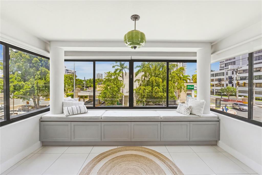 A sunroom features a built-in window seat, white tile flooring, and a green pendant light — 1504 AVE. ASHFORD, COND. SEA VIEW UNIT 2C, SAN JUAN, PR