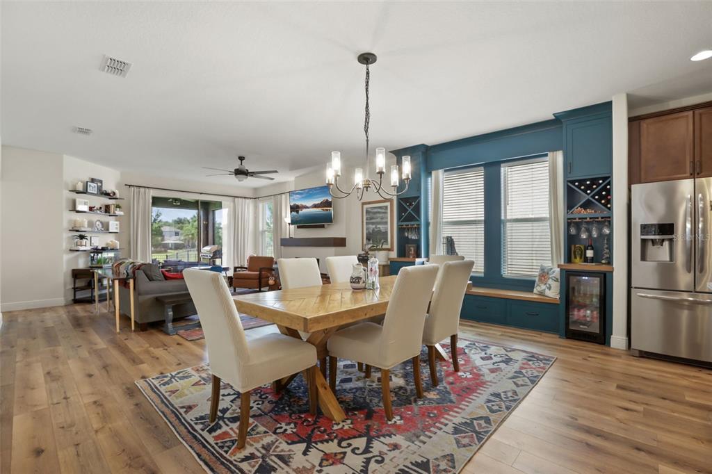 A covered brick porch features a dark front door, two white rocking chairs, and windows — 16082 HAMPTON CROSSING DRIVE, WINTER GARDEN, FL
