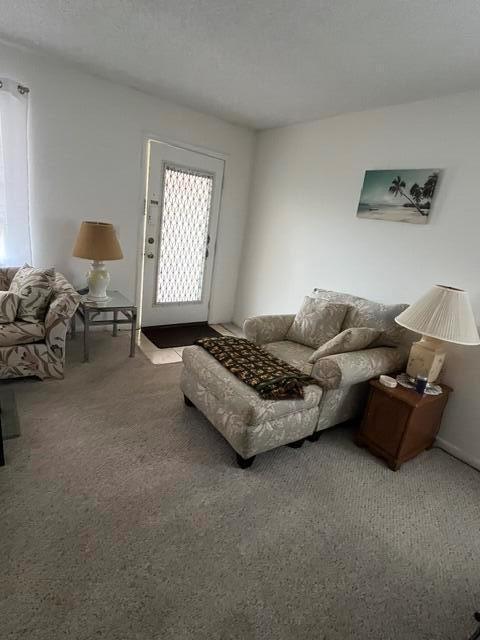 A living room features a patterned armchair with an ottoman, two side tables, and lamps — 351 Capri H # 351, Delray Beach FL 33484, DELRAY BEACH, FL