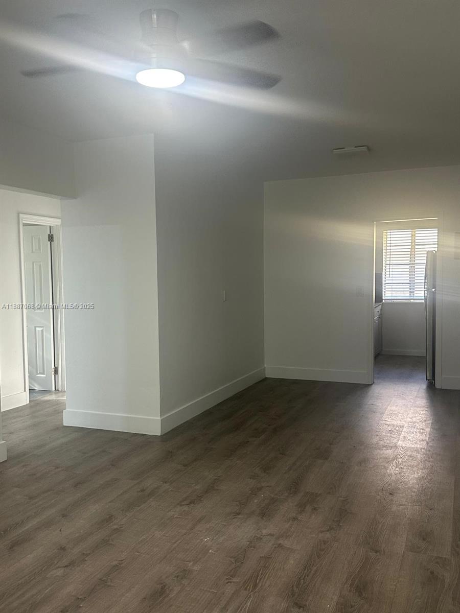 This room features white walls, a ceiling fan, and dark wood-look flooring — 6805 Abbott Ave # 1, Miami Beach FL 33141, MIAMI BEACH, FL